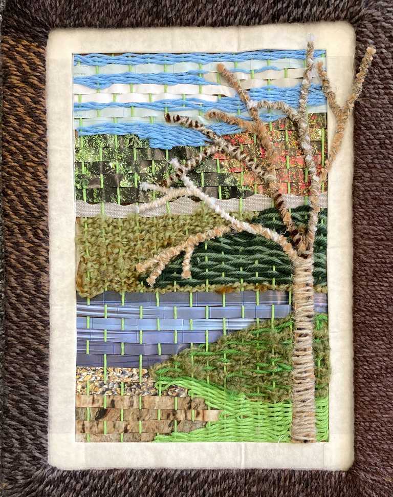 Magazine paper and wool weaving in frame with pipe cleaner tree
